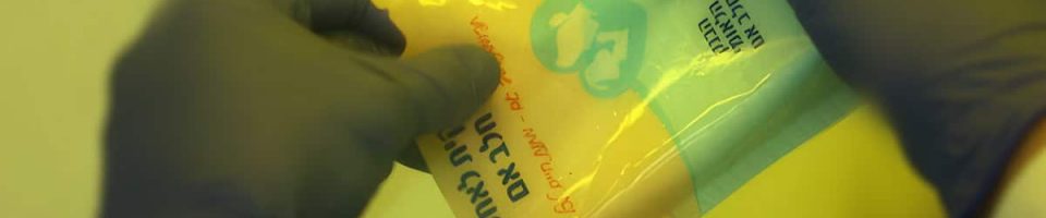 Gloved hands pour donor milk from a Magen David Adom milk bank bag into a jar
